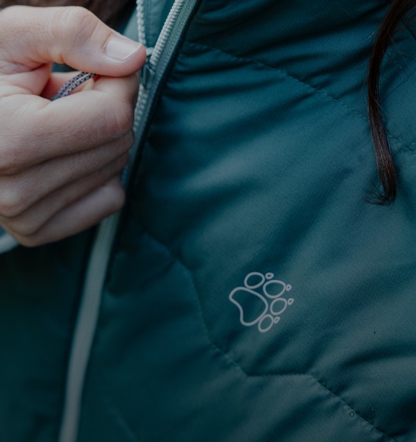 Close-up van een hand bij de rits van een jas