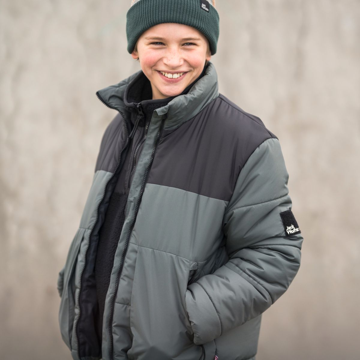 Jongen met winterjas lacht