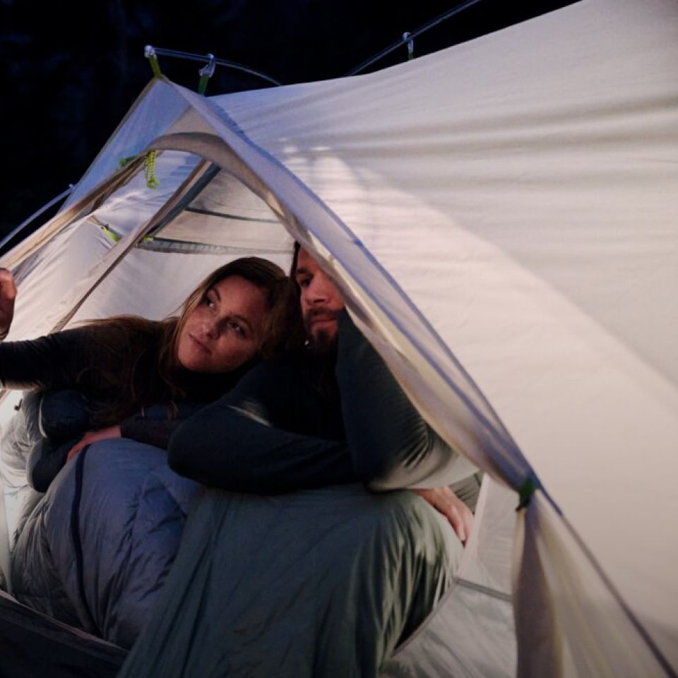 Een vrouw en een man in een tent in het donker