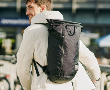 Man met rolltop-rugzak op de rug