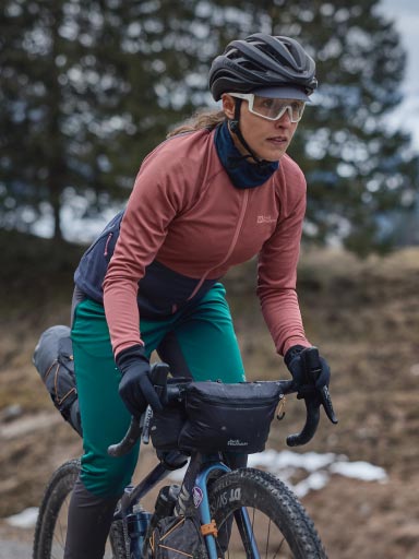 Man met fietsshirt haalt een flesje drinken uit zijn buiktasje