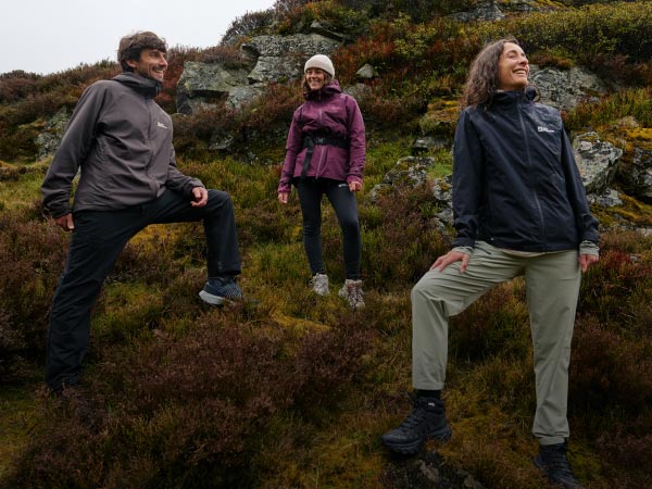 Twee lachende vrouwen in een berglandschap zetten een tent op