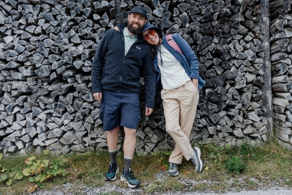 Jonge vrouw in sportieve wandelkleding hurkt op een rots in het&nbsp;donker